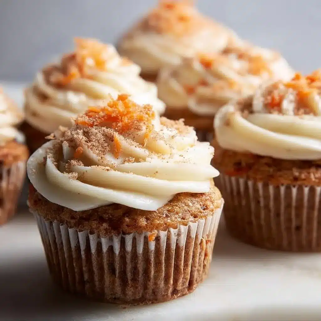 Delicious carrot cake cupcakes topped with creamy frosting on a decorative plate