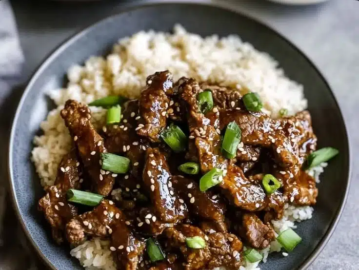 Delicious plate of Mongolian Beef served with green onions and rice
